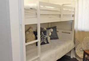 Amity Point的住宿－ATALLAWA，客房内的一张白色双层床和长凳