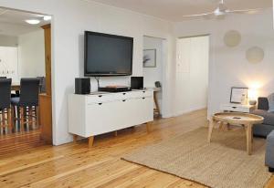 een woonkamer met een flatscreen-tv op een wit dressoir bij ATALLAWA in Amity Point