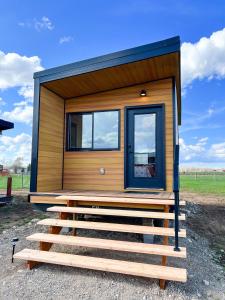 une petite maison avec une grande porte et une véranda dans l'établissement Tiny Home with Spectacular Teton View, à Driggs