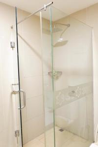 a shower with a glass door in a bathroom at Vega Prime Hotel & Convention in Sorong