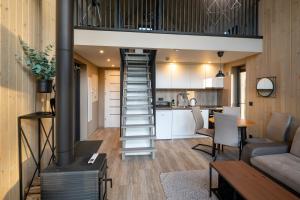 a living room and kitchen with a staircase in a tiny house at Hytte Na Wyspie -,,Roztoczańskie Morze'' in Kulików