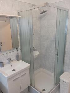 ein Bad mit einer Dusche und einem Waschbecken in der Unterkunft Apartment Fontana Felicita in Zadar