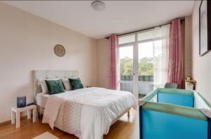 ein Schlafzimmer mit einem Bett und einem großen Fenster in der Unterkunft luxe Paris Ris in Ris-Orangis