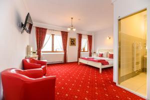 1 dormitorio con 1 cama y alfombra roja en Panoramic Center Rooms en Brasov