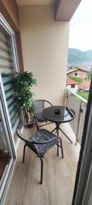 a balcony with a table and a table and a chair at Marinkovic stan na dan in Vranje