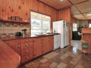 cocina con armarios de madera y nevera blanca en ALOHA AMITY, en Amity Point