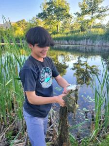 een jonge jongen met een vis op een boom in het water bij Heaven's Ridge Vacation Home in Waynesville