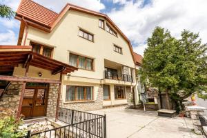 a large house with a fence in front of it at Panoramic Center Rooms in Braşov
