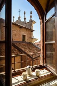 an open window with two tea cups on a balcony at LA CASA DEL CASTELLANO in Cinzano
