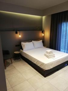 a bedroom with a large bed with white sheets and pillows at Dolora's in Methana