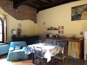 a living room with a table and a kitchen at LA CASA DEL CASTELLANO in Cinzano