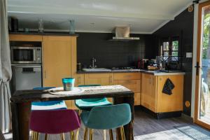 a kitchen with a table and some chairs at Cottage, Lodge & Spa 64 in Prouilly