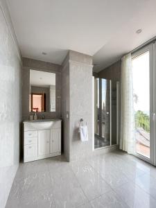 een badkamer met een wastafel en een spiegel bij Villa l'ensoleillée vue panoramique mer, 250 m de la plage et du centre ville in Menton