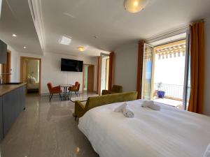 Pokój hotelowy z dużym łóżkiem i salonem w obiekcie Villa l'ensoleillée vue panoramique mer, 250 m de la plage et du centre ville w Mentonie