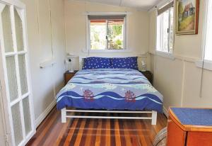 a small bedroom with a bed in a room with windows at ANCHORAGE in Amity Point
