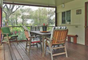 a porch with a table and chairs on a deck at ANCHORAGE in Amity Point