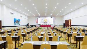 a large room with tables and chairs and a screen at Vega Prime Hotel & Convention in Sorong