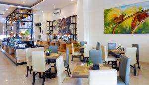 a restaurant with tables and chairs and a painting on the wall at Vega Prime Hotel & Convention in Sorong