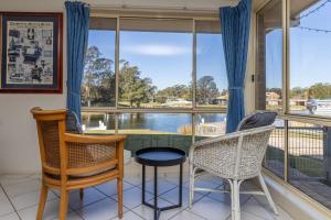a room with a large window with chairs and a table at Holiday on the Water in Sussex Inlet