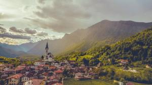 a small town in the mountains with a church at Hiša Nataša in Drežnica