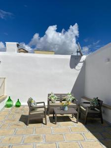a patio with two benches and a white wall at Nonna Cia in Gallipoli