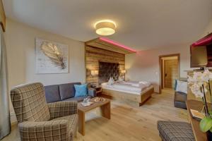 a living room with a couch and a bed at Wellnesshotel Hofbräuhaus in Bodenmais +66 photos