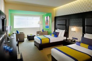 Habitación de hotel con 2 camas y sofá en Hues Boutique Hotel, en Dubái