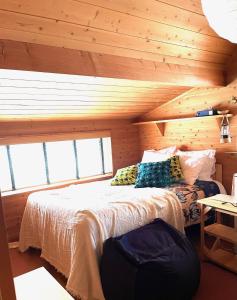 1 dormitorio con 1 cama en una cabaña de madera en 1組限定ドッグフレンドリー&イギリス料理 Laughing dogs villa, en Takashima