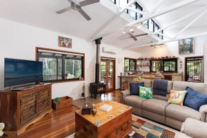 a living room with a couch and a tv at Eclectic Oasis in Doonan, Sunshine Coast in Doonan