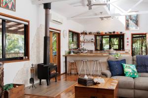 a living room with a couch and a stove at Eclectic Oasis in Doonan, Sunshine Coast in Doonan