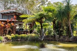 una casa con un estanque delante de ella en Eclectic Oasis in Doonan, Sunshine Coast, en Doonan