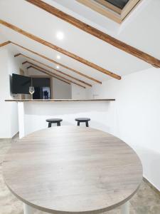 a large wooden table in a room with two stools at Apartman Valja - 55m2 - Sea View - Garden - Grill in Jadranovo