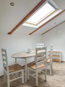 a table and chairs in a room with a skylight at Apartman Valja - 55m2 - Sea View - Garden - Grill in Jadranovo