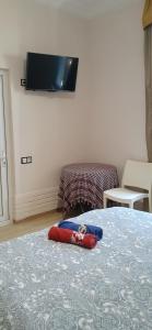 a room with a bed with a tv on the wall at шорена in Batumi