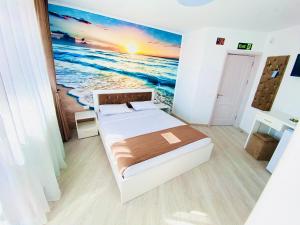 - une chambre avec un lit et une peinture sur l'océan dans l'établissement IANIS Rooms, à Mangalia