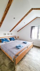 a bedroom with a large bed with blue pillows at Apartman Valja - 55m2 - Sea View - Garden - Grill in Jadranovo