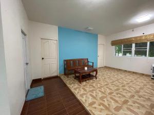 uma sala de estar com um banco e uma parede azul em K house em Ban Bang Khen (1)