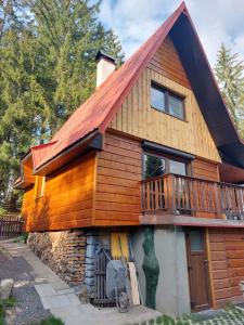 une cabane en rondins avec une véranda et une terrasse dans l'établissement Chata u lesa, à Prostřední Bečva