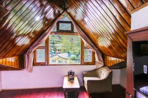 a room with a couch and a table and a window at MHA hotels MOORANG mall manali in Manāli