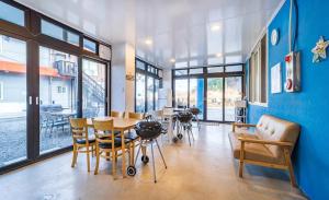 a dining room with a table and chairs and a blue wall at Sky Sea Pension in Yangyang