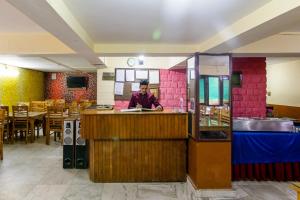 a person standing behind a counter in a restaurant at MHA hotels MOORANG mall manali in Manāli