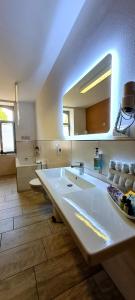a large bathroom with two sinks and a large mirror at Pension Schul Inn in Ruhla