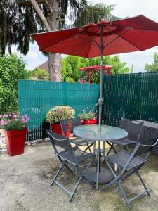 a table and chairs with a red umbrella at Altéa in Pessac