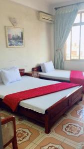 2 camas en una habitación con ventana en Xuân Mỹ Hostel Bãi Cháy, en Ha Long