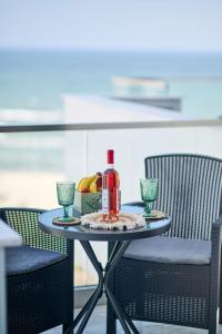 een tafel met een fles wijn en twee glazen bij AdeMar Luxury Apartment- Spa&Pool Beach Resort in Mamaia