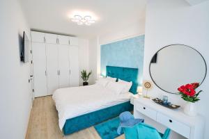een slaapkamer met een bed met een spiegel en een bureau bij AdeMar Luxury Apartment- Spa&Pool Beach Resort in Mamaia
