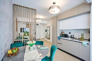 eine Küche und ein Esszimmer mit Tisch und Stühlen in der Unterkunft AdeMar Luxury Apartment- Spa&Pool Beach Resort in Mamaia