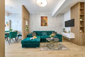 ein Wohnzimmer mit einer grünen Couch und einem Tisch in der Unterkunft AdeMar Luxury Apartment- Spa&Pool Beach Resort in Mamaia