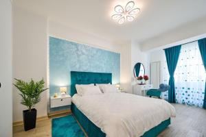 ein Schlafzimmer mit einem großen Bett mit blauem Kopfteil in der Unterkunft AdeMar Luxury Apartment- Spa&Pool Beach Resort in Mamaia + 61 Fotos