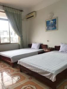 1 dormitorio con 2 camas y ventana en Xuân Mỹ Hostel Bãi Cháy, en Ha Long